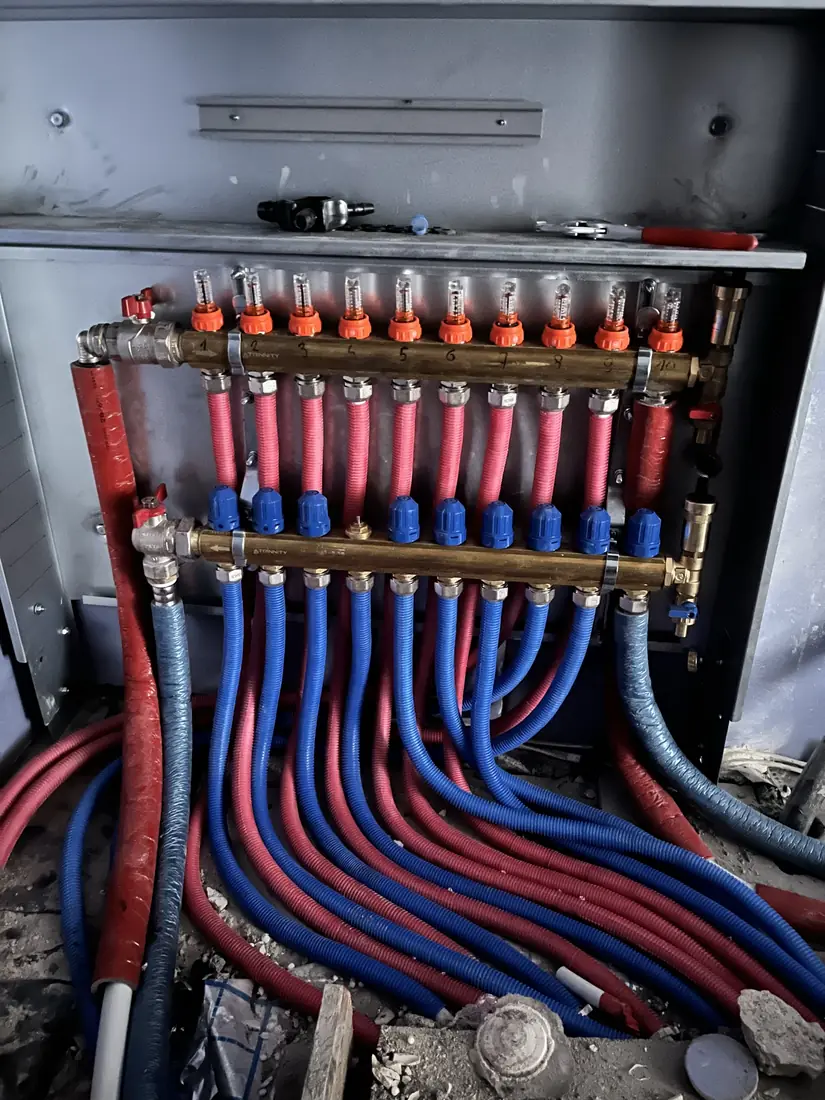 Rozdzielacz instalacji wodnej z czerwonymi i niebieskimi przewodami